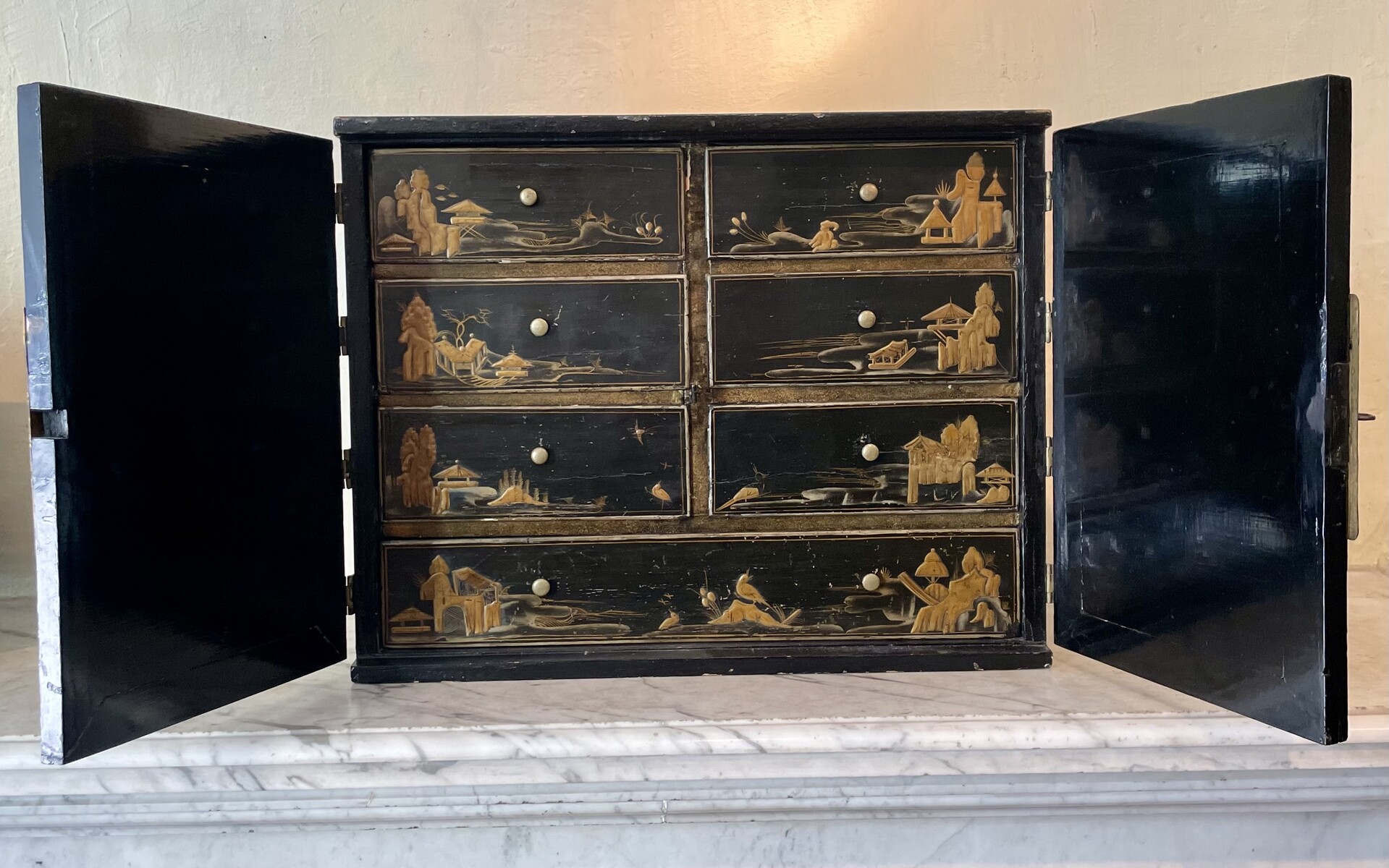 Cabinet with è drawers behind two doors decorated with Chineesee-like lacquer.