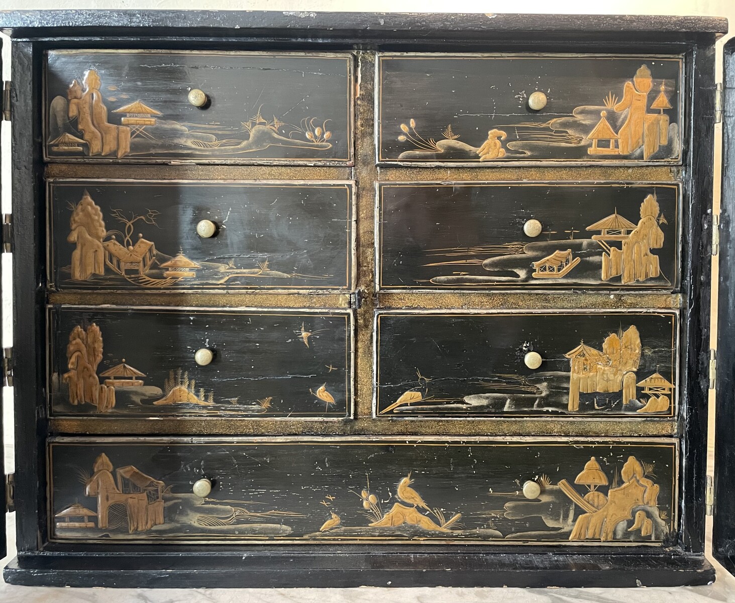 Cabinet with è drawers behind two doors decorated with Chineesee-like lacquer.