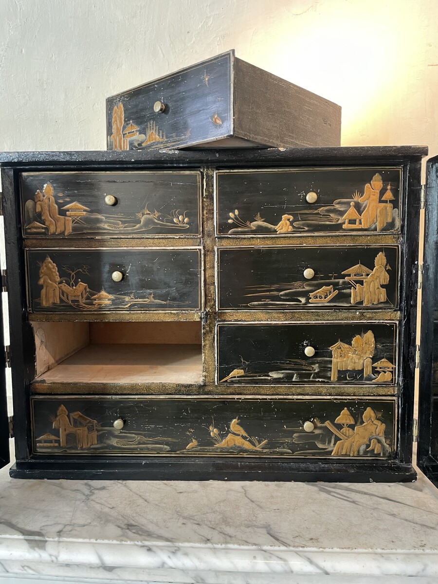 Cabinet with è drawers behind two doors decorated with Chineesee-like lacquer.