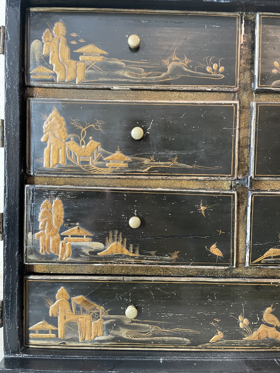 Cabinet with è drawers behind two doors decorated with Chineesee-like lacquer.