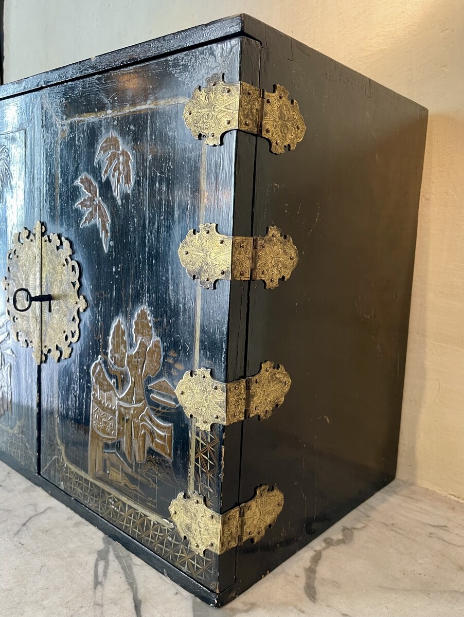 Cabinet with è drawers behind two doors decorated with Chineesee-like lacquer.