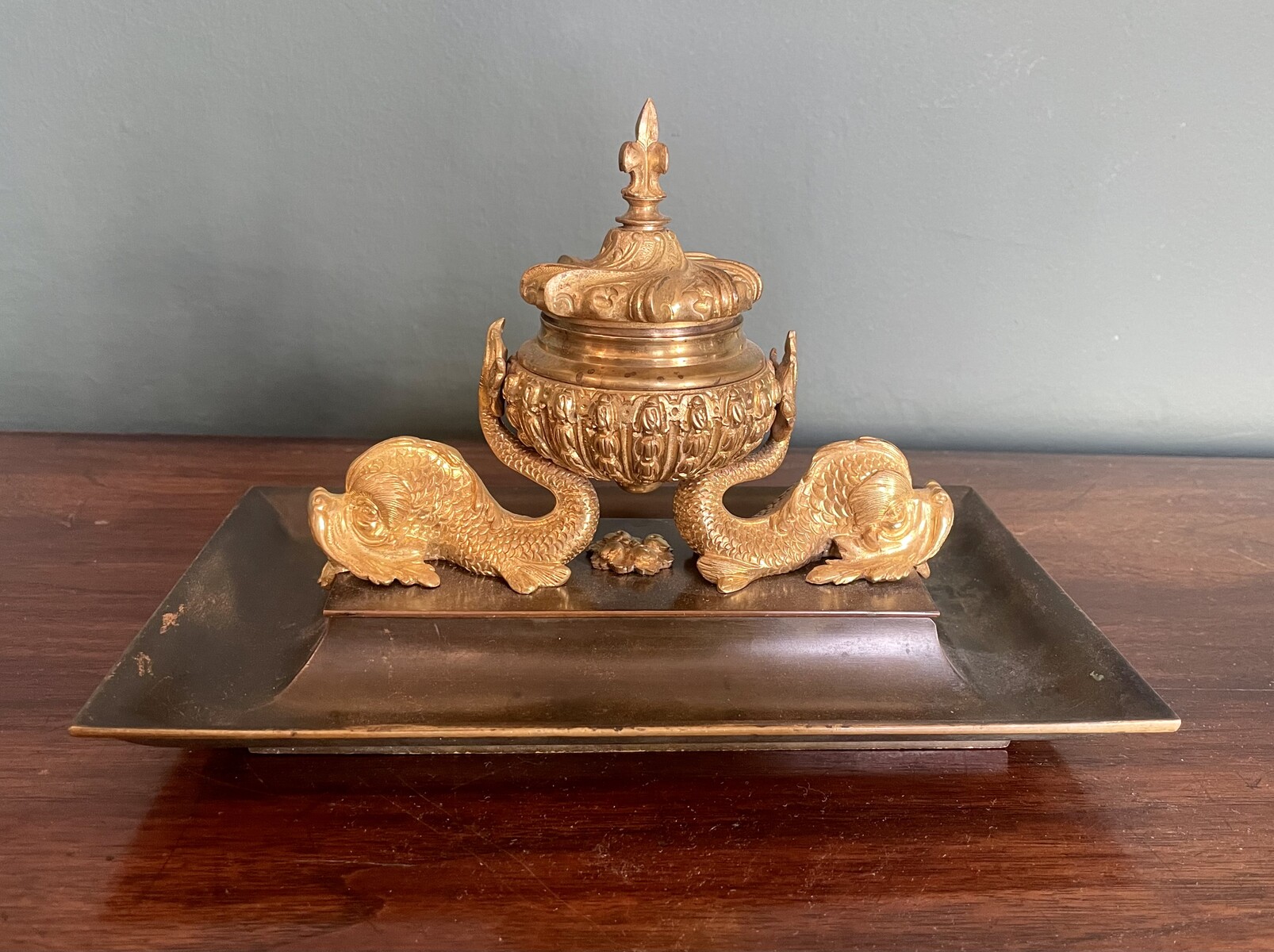 inkwell decorated with dolphins and a lily flower