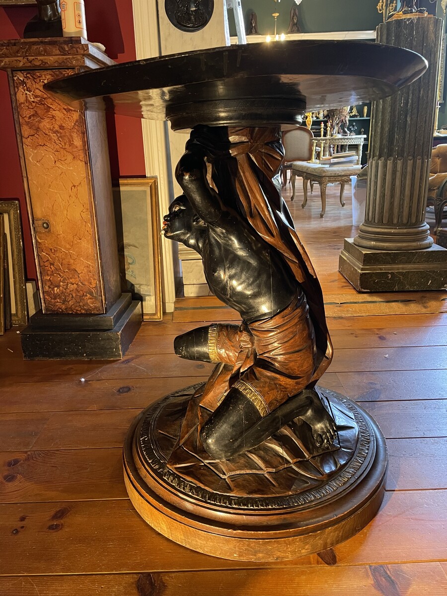 Moor-shaped gueridon supporting a carved circuar top