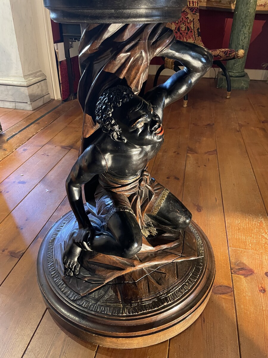 Moor-shaped gueridon supporting a carved circuar top