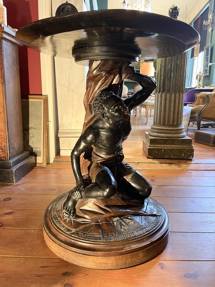 Moor-shaped gueridon supporting a carved circuar top