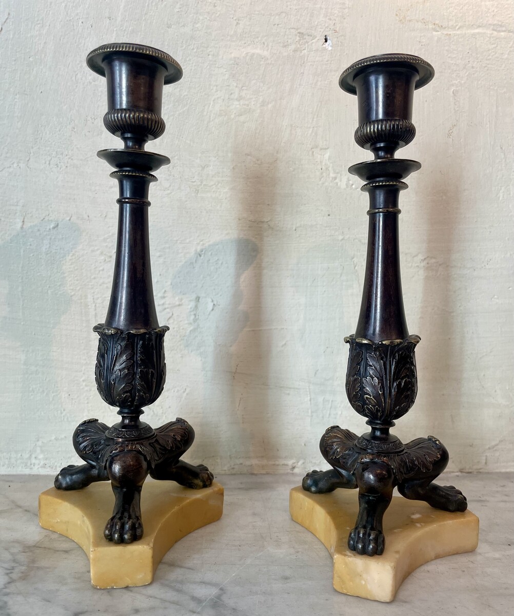 Pair of Restoration style tripod candlesticks on a marble base.