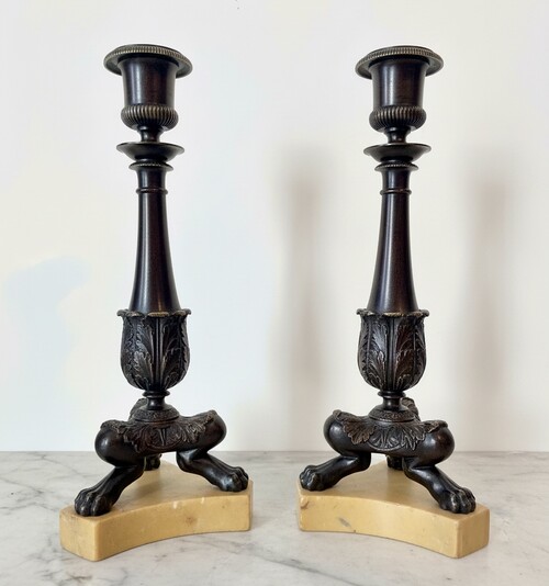 Pair of Restoration style tripod candlesticks on a marble base.