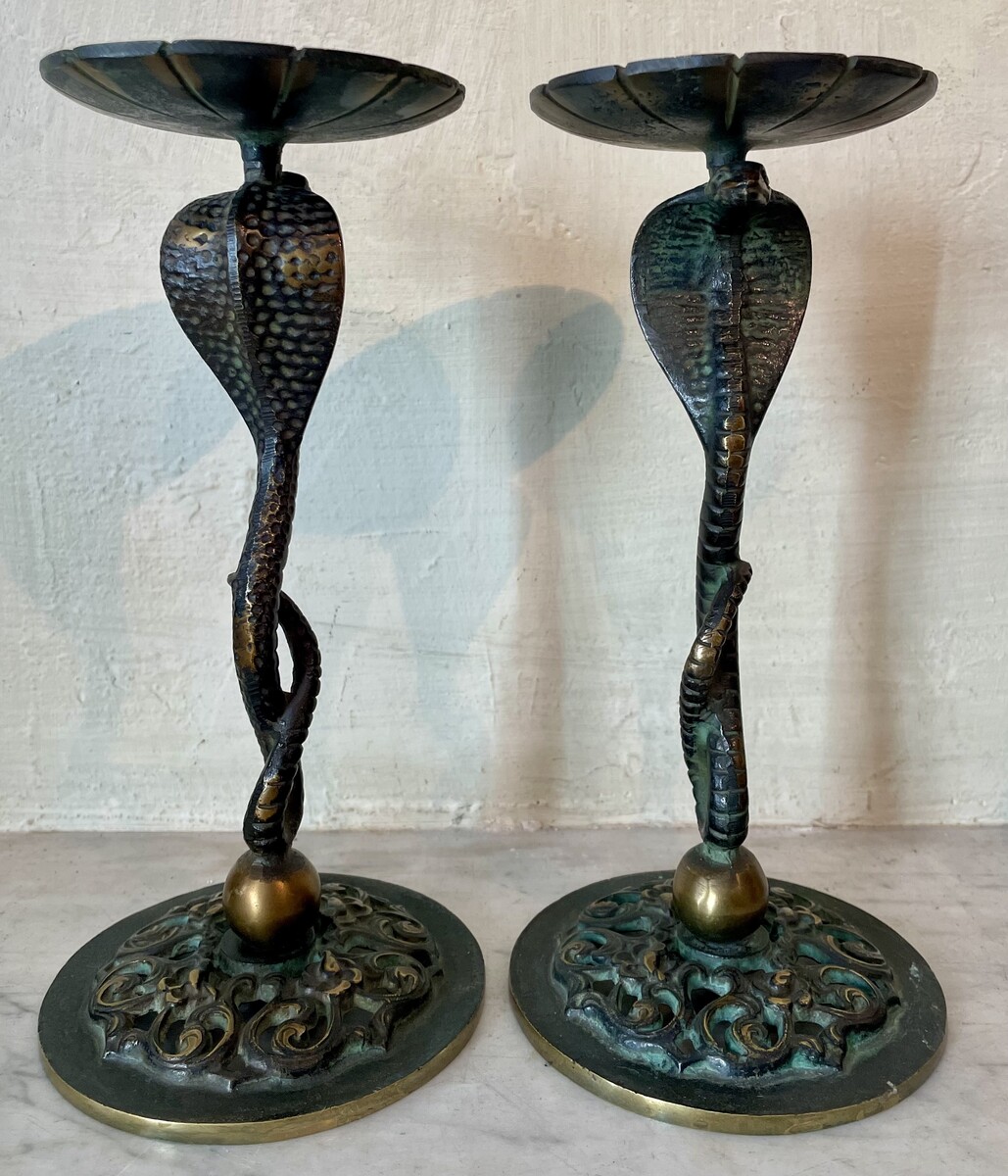 Small candle sticks in the shape of a snake. Openwork base with arabesque decoration