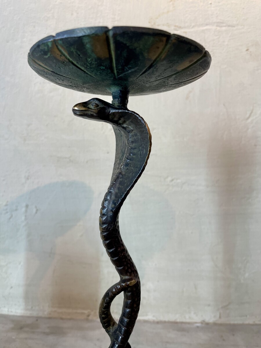 Small candle sticks in the shape of a snake. Openwork base with arabesque decoration