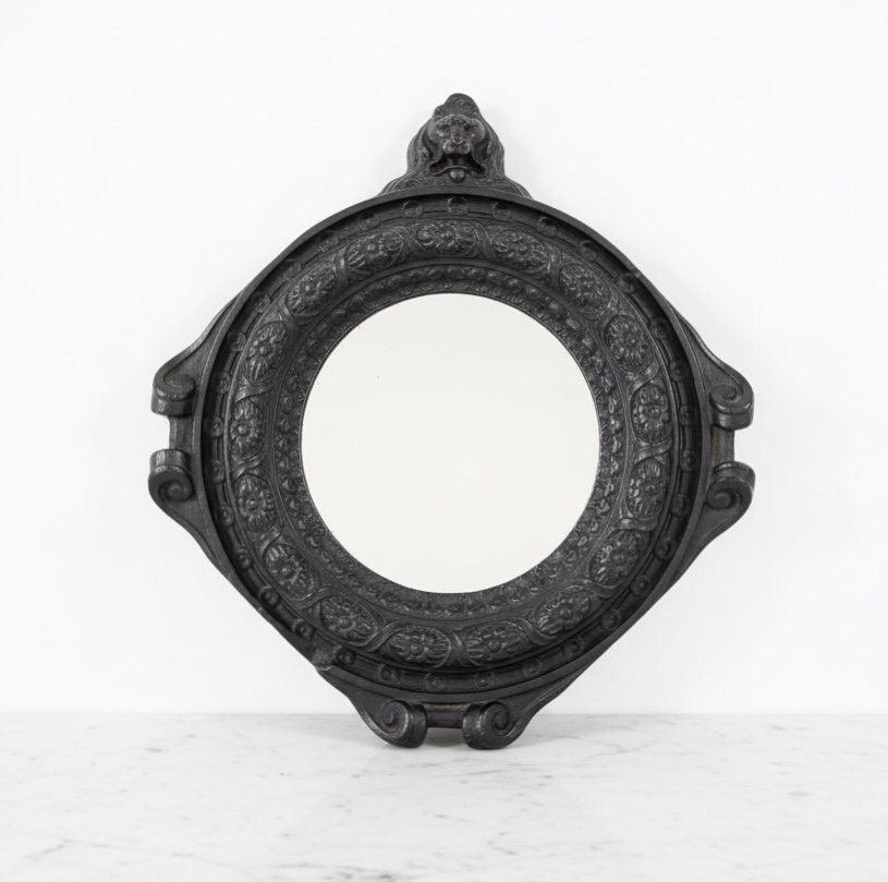 Small round mirror, decorated with flower frieze and lion bust, Regence period