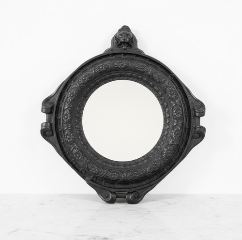 Small round mirror, decorated with flower frieze and lion bust, Regence period