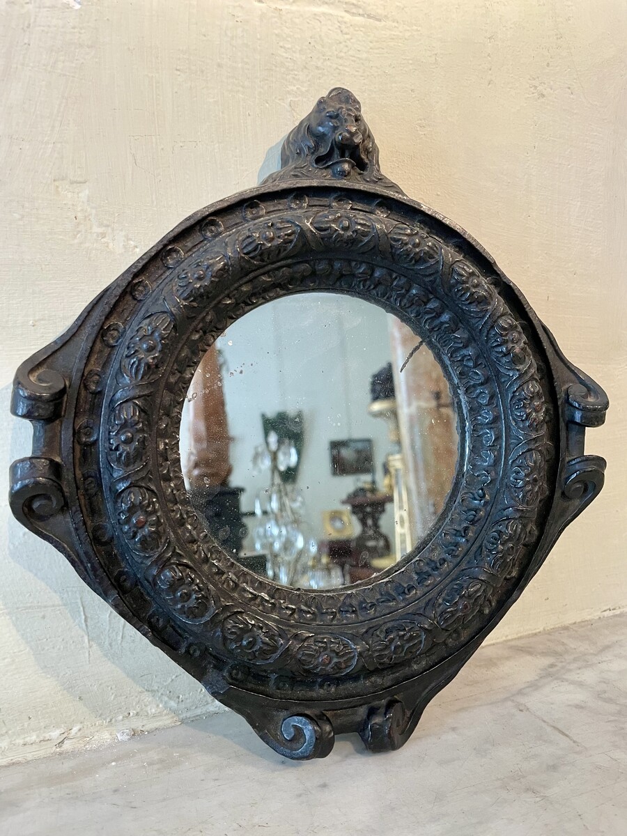 Small round mirror, decorated with flower frieze and lion bust, Regence period