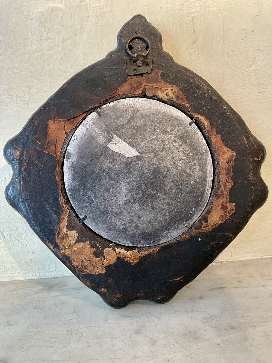 Small round mirror, decorated with flower frieze and lion bust, Regence period